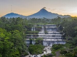Menikmati Indahnya Grojogan Watu Purbo Dengan Latar Belakang Gunung Merapi